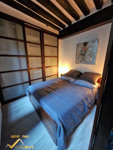 une chambre avec un lit avec un tableau sur le mur dans l'établissement Le Graveur Saint Maclou, Hyper centre, Typique Rouennais, à Rouen