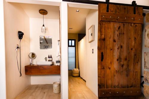 an open barn door in a bathroom with a sink at Brisa Del Valle Hotel Boutique in Valle de Guadalupe