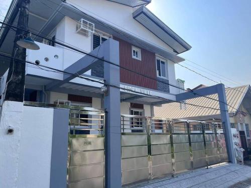 a house with a fence in front of it at Sidra Ville Apartment in Balanga