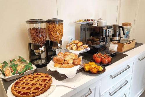 a counter with many different types of pastries and pies at Rooms AL-Zabut in Sambuca di Sicilia
