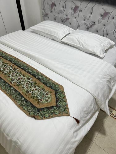 a white bed with a blanket and pillows on it at ضيافة الأمير The Prince Hospitality in Barka
