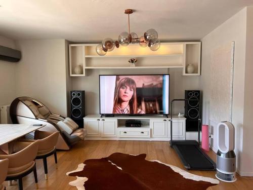 a living room with a tv with a woman on it at Kordon İstanbul Luxury House 3+1 in Istanbul