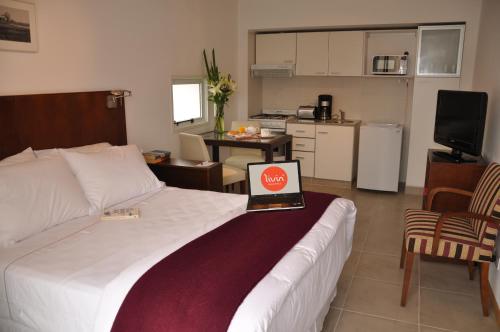 a bedroom with a bed with a laptop on it at Livin' Residence Rosario in Rosario