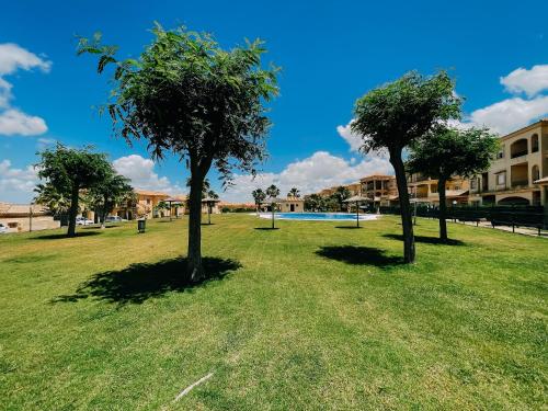 a park with three trees in the grass at DeCapi House in Sanlúcar de Barrameda