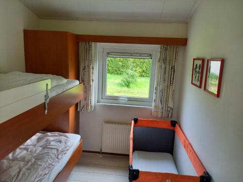 a small bedroom with a bunk bed and a window at Chaletbos Voorthuizen Stroe Garderen in Voorthuizen