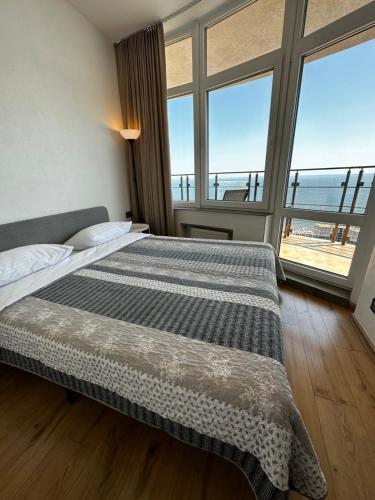 a bedroom with a bed with a view of the ocean at Arcadia apartment & sea terrace in Odesa