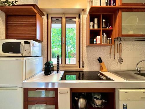 a kitchen with a sink and a white refrigerator at Beach house with private garden and parking in Grado-Pineta