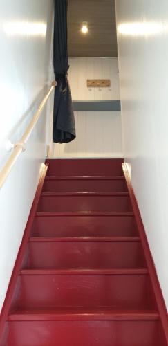 a staircase with red steps in a room at Aux Passagers de la baie 2 in Le Crotoy