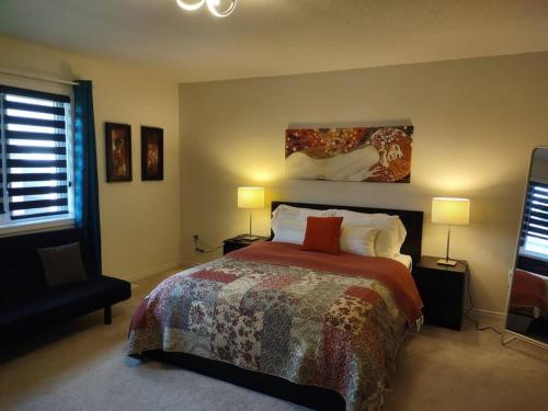 a bedroom with a large bed and two lamps at A home away from home in Niagara Falls