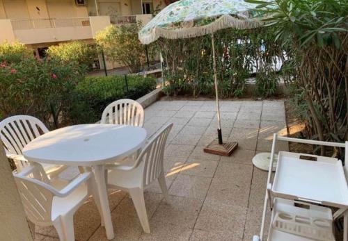 a table and chairs with an umbrella on a patio at Studio 27 m2 avec terrasse 20m2 in Six-Fours-les-Plages