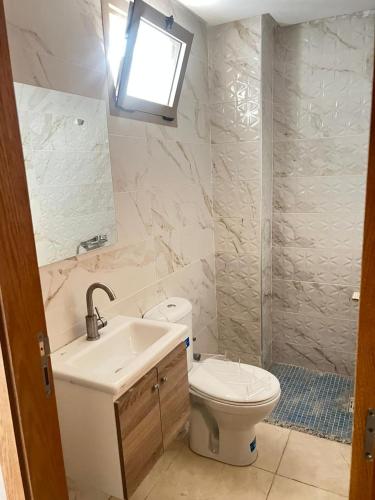 La salle de bains est pourvue de toilettes et d'un lavabo. dans l'établissement Adorable Appartement meublé en plein centre ville, à Kenitra