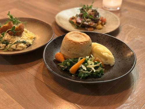 three plates of food on a wooden table at The George Hotel Easingwold in Easingwold