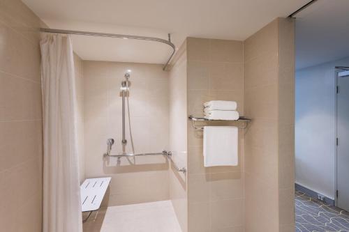 a bathroom with a shower and a toilet and towels at Four Points by Sheraton Perth in Perth