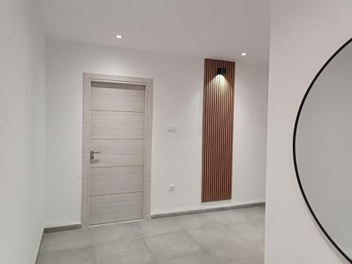 a hallway with a door and a mirror at Logement Chic, résidence azaléa - Alger in Draria