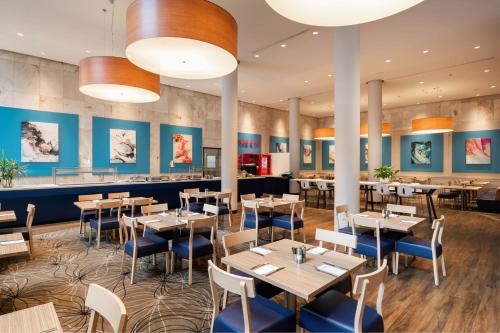 un restaurante con mesas, sillas y paredes azules en Four Points by Sheraton Perth, en Perth