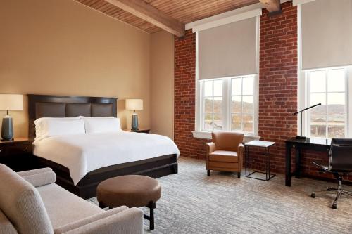 Habitación de hotel con cama, sofá y sillas en Craddock Terry Hotel, Lynchburg, a Tribute Portfolio Hotel, en Lynchburg
