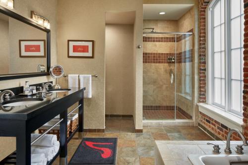 y baño con 2 lavabos y ducha. en Craddock Terry Hotel, Lynchburg, a Tribute Portfolio Hotel, en Lynchburg