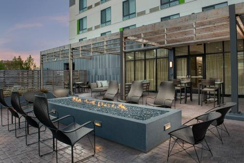 a patio with chairs and a fire pit in front of a building at Courtyard Portland East in Portland