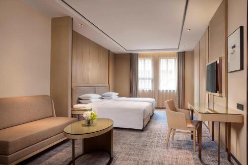 a hotel room with a bed and a couch at Courtyard by Marriott Shanghai International Tourism and Resorts Zone in Shanghai