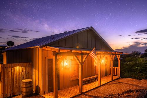 a wooden building with lights on the front at night at -Pet Friendly- Miners Cabin #6 - King Bed with Private Balcony in Tombstone