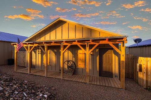a barn with a flag on the front of it at -Pet Friendly- Miners Cabin #6 - King Bed with Private Balcony in Tombstone