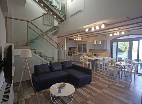 a living room with a couch and a table and a kitchen at Ciel Villa in Kalyves