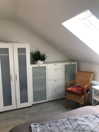 a bedroom with a bed and a chair and cabinets at Ferienwohnung-Ameisenhardt in Schleiden