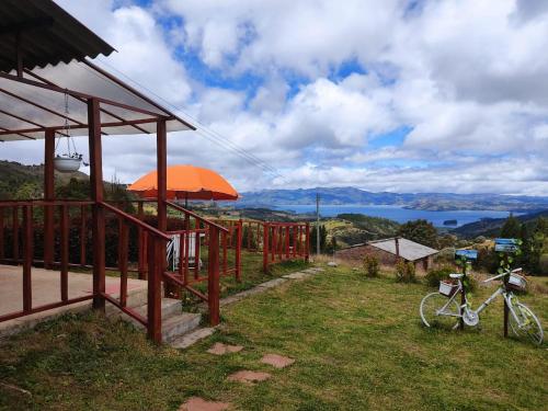 una bicicleta estacionada al lado de un edificio con un paraguas naranja en Balcones del Lago de Tota, en Sogamoso