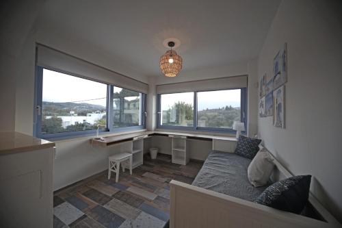 a room with a bed and a desk and two windows at Ciel Villa in Kalyves
