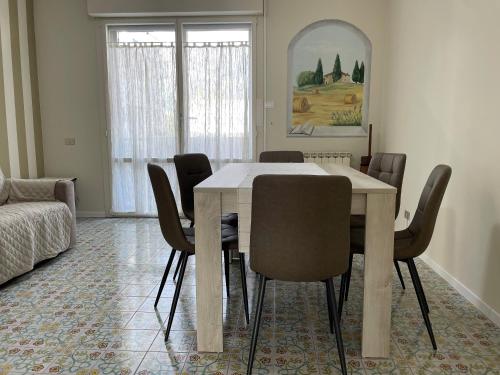 een eetkamer met een witte tafel en stoelen bij Stefano's Guests House: 2 bedrooms & parking in Viareggio in Viareggio