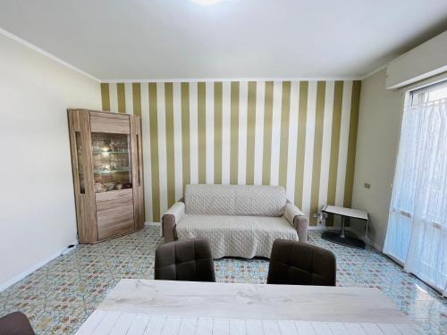 een kamer met een stoel, een tafel en een raam bij Stefano's Guests House: 2 bedrooms & parking in Viareggio in Viareggio