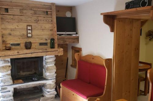 - un salon avec une cheminée et un fauteuil rouge dans l'établissement La Lotière, à Fontaine-le-Puits