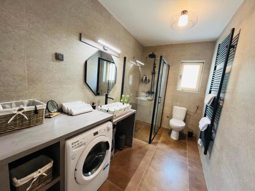 a bathroom with a washing machine and a toilet at Holiday House Marin in Selno