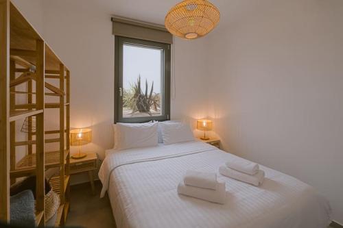 a bedroom with a bed with two white towels on it at Lemon Hill Villa / Landmark Hosting in Finikounta