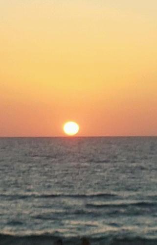 a sunset over the ocean with the sun in the horizon at B&B DA SILVESTRO in Tempio Pausania