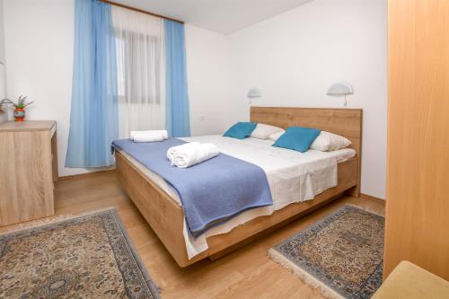 ein Schlafzimmer mit einem Bett mit zwei Kissen darauf in der Unterkunft Apartments and Room Novokmet in Rogoznica