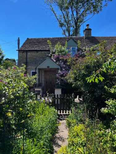 a house with a garden with flowers at Characterful, Cosy Cotswold Cottage, Folly Cottage in Avening