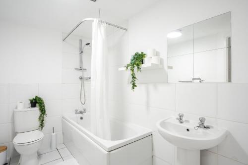 a white bathroom with a toilet and a sink at Stylish 2 Bed Manchester Flat in Manchester