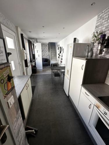 une cuisine avec des appareils électroménagers blancs et une salle à manger dans l'établissement CHAcabuLONS, à Châlons-en-Champagne