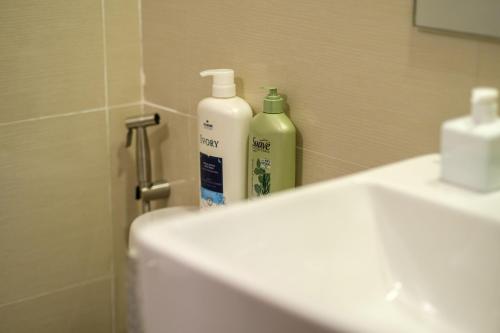 een badkamer met 2 flessen zeep en een wastafel bij Uptown Parksuites Modern Room in Manilla