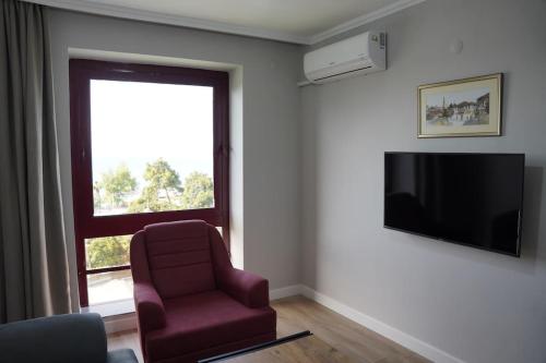 a living room with a chair and a television at Royal Homes 402 in Antalya