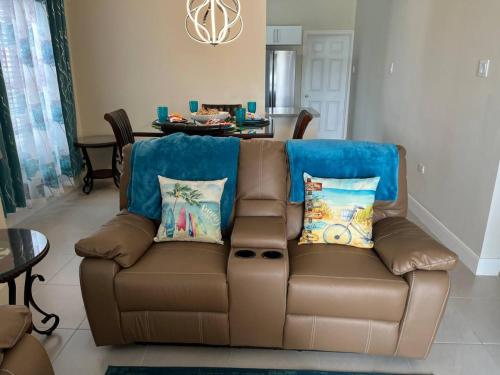 Spacious apartments Crystal Waters في لوتسيا: أريكة بنية مع الوسائد في غرفة المعيشة