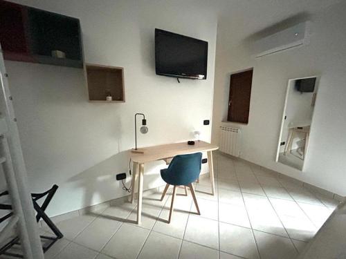 a room with a table and a chair and a tv at B&B Casa Letizia in Trentinara