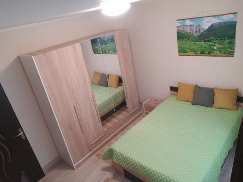 a small room with a mirror and a bed at Zoldrebi apartment in Turda