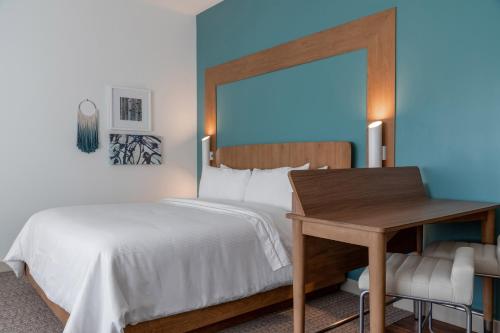 a bedroom with a bed and a table and a desk at Element Dallas Richardson in Richardson