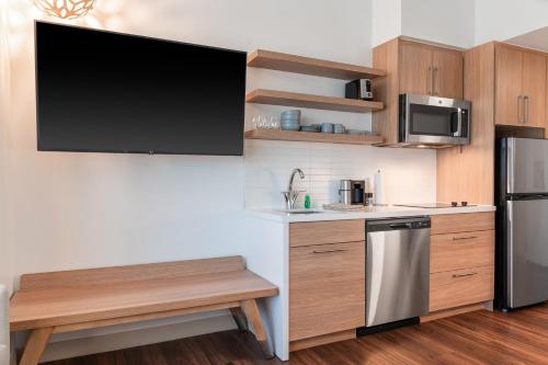 a kitchen with a large tv on the wall at Element Dallas Richardson in Richardson
