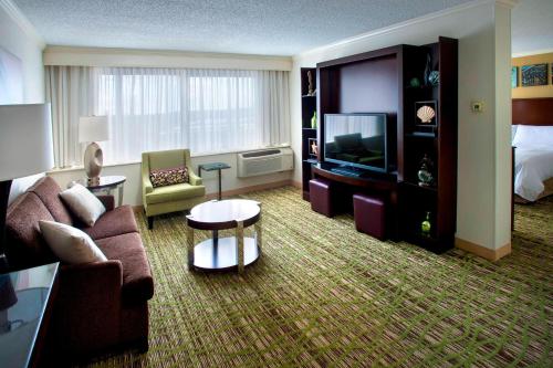 a hotel room with a couch and a television at Boston Marriott Peabody in Peabody
