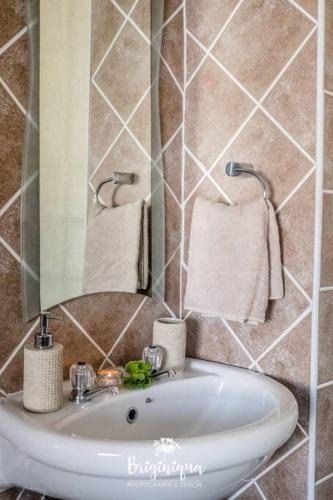 a bathroom with a sink and a mirror and towels at * 281 Golden Mile Boulevard in St. Helena Bay