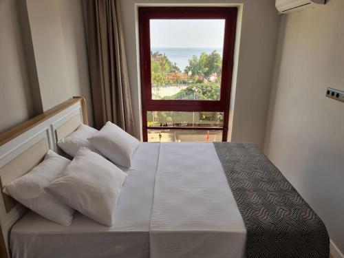 a bedroom with a white bed with a window at Royal Homes 403 in Antalya