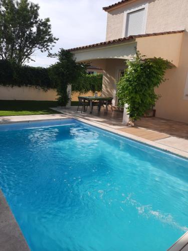 een groot blauw zwembad voor een huis bij Dépendance avec piscine et jardin privés sans vis-à-vis in Montarnaud